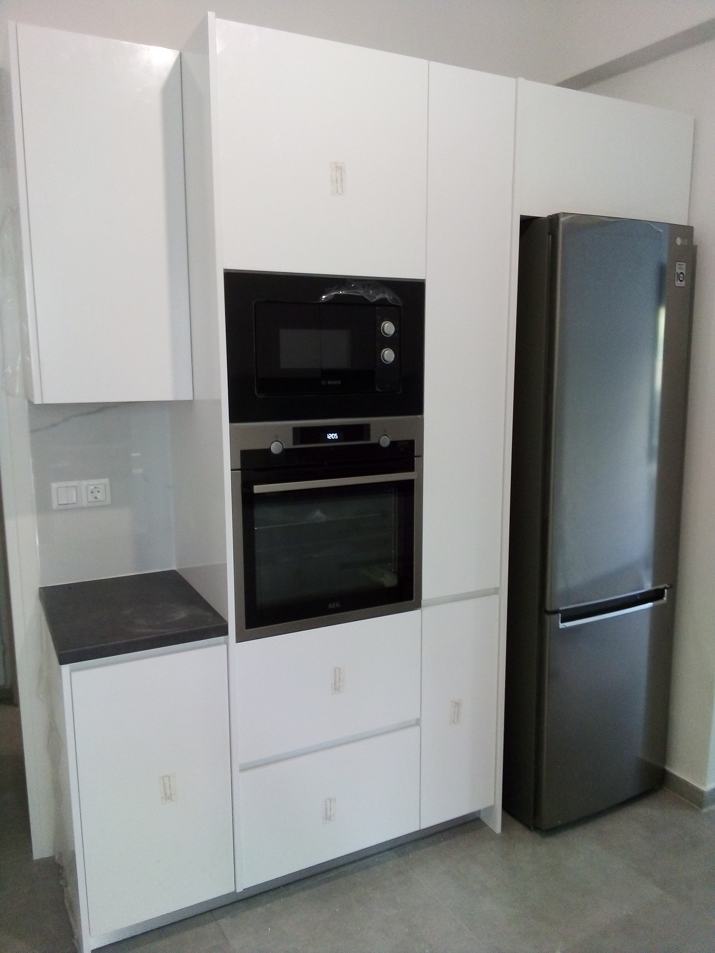 Γυαλιστερή λευκή laminate κουζίνα χωρίς χειρολαβές με κολόνα φούρνου